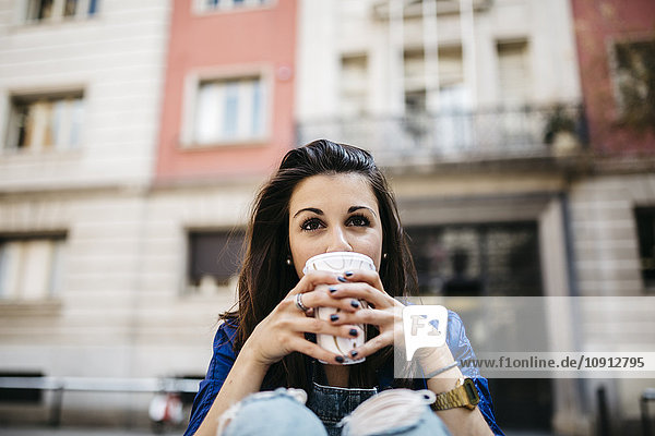 Spain  Barcelona  young woman with a coffee in the city