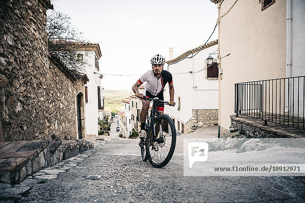 Mountain biker riding uphill in mountain village
