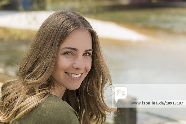 Portrait of smiling young woman at a river