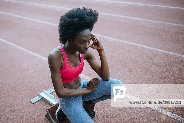 Young black athlete preparing for race in stadium