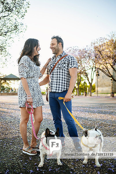 Happy couple walking their dogs
