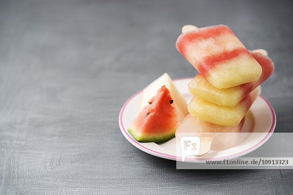 Teller mit Stapel von verschiedenen hausgemachten Melonen-Eis-Lollies