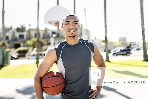 Portrait of confident basketball player on outdoor court