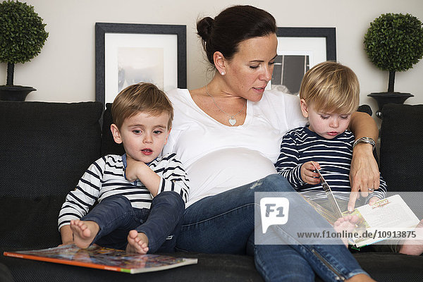 Mother reading book with her sons