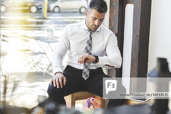Businessman in a cafe checking the time