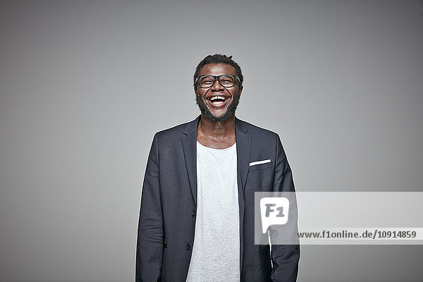 Porträt eines lachenden Mannes mit Brille und Jacke