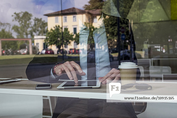 Geschäftsmann in einem Café mit digitalem Tablett