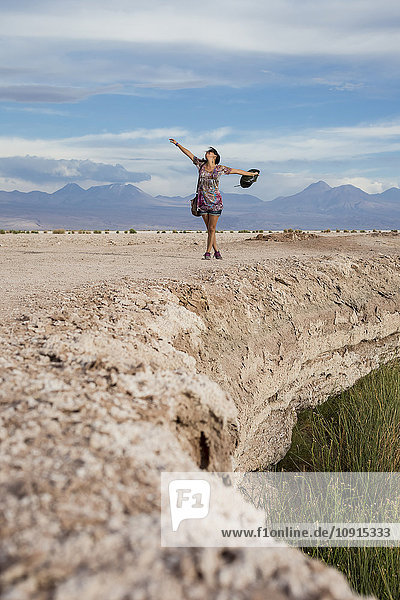 Chile  San Pedro de Atacama  woman in the desert with outstretched arms