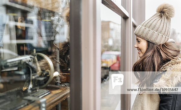 UK,  London,  Notting Hill,  junge Frau schaut auf Schaufensterauslage