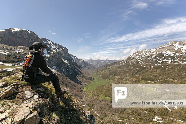 Spain  Asturias  Somiedo  man looking at the landscape sitting on mountaintop