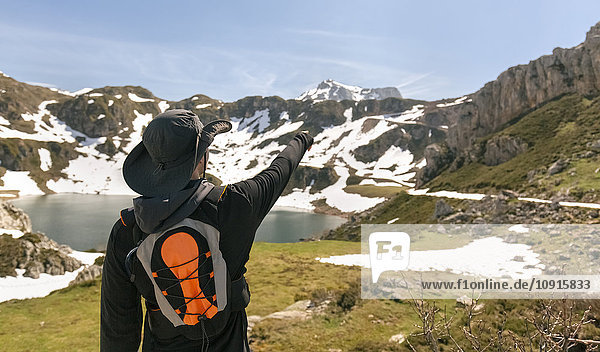 Spanien  Asturien  Somiedo  Mann  der mit dem Finger auf die Berge zeigt.