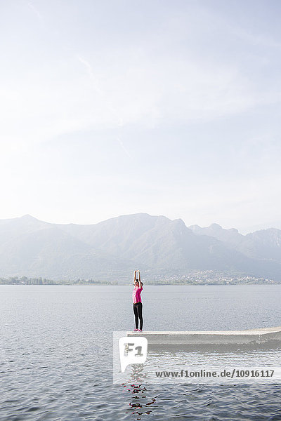 Italien  Lecco  junge Frau  die sich am See ausstreckt