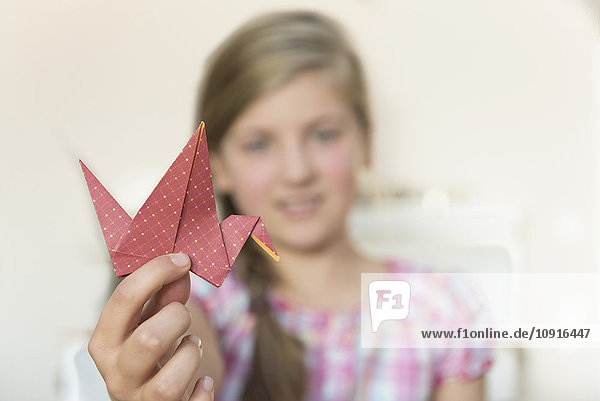 Mädchen mit Origami-Vogel