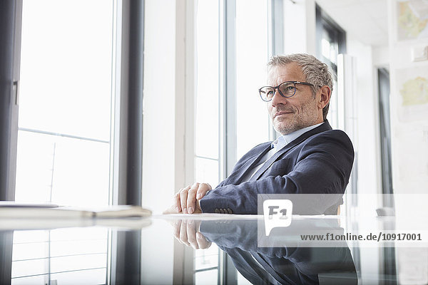 Successful businessman sitting at desk in his office