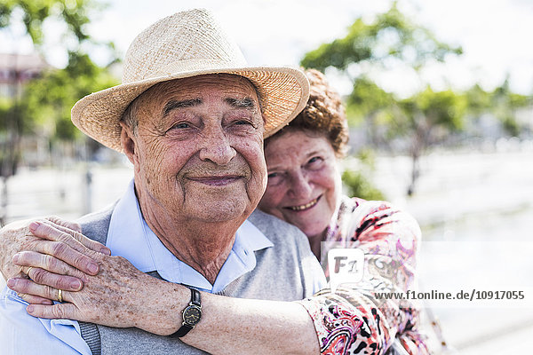 Porträt des glücklichen Senior mit seiner lächelnden Frau im Hintergrund