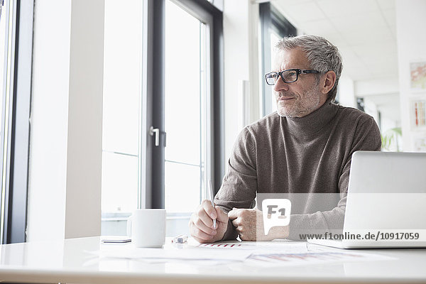 Mature man sitting relaxed in office