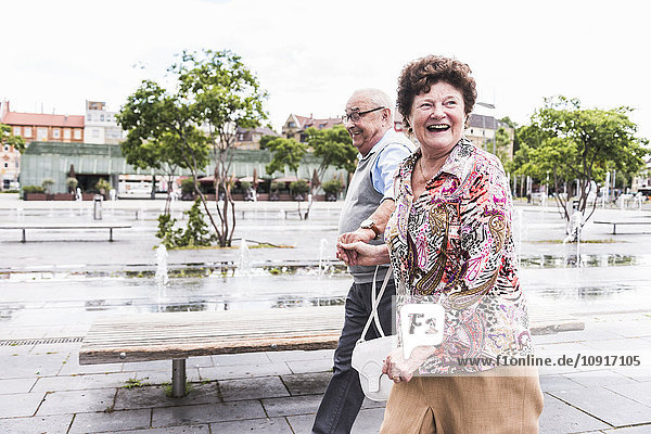 Germany  Mannheim  happy senior couple walking hand in hand