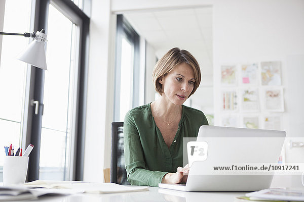 Businesswoman working on laptop at office desk