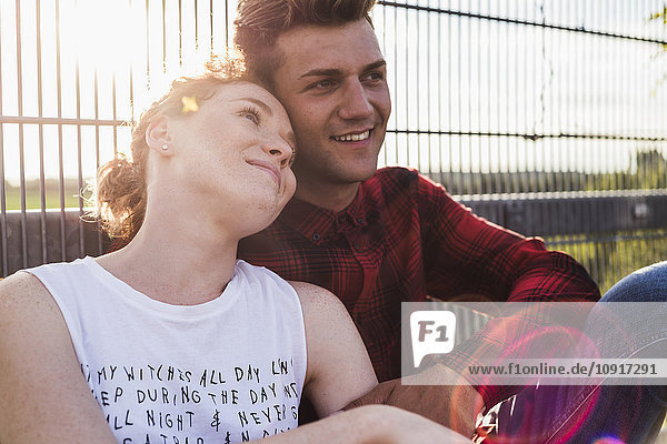 Lächelndes junges Paar am Zaun