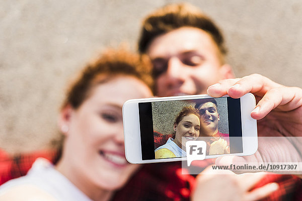 Selfie des jungen Paares im Liegen