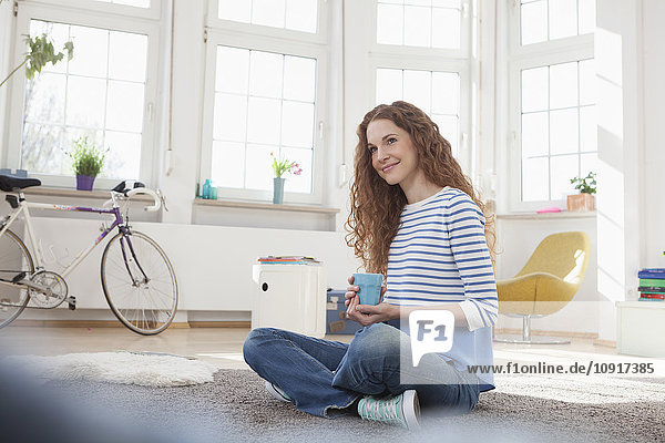 Smiling woman at home sitting on floor