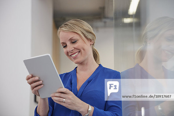 Geschäftsfrau im Büro mit digitalem Tablett