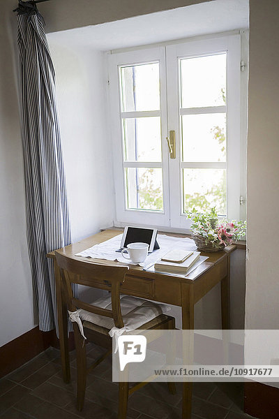Digitales Tablett  Bücher und Kaffeetasse auf dem Schreibtisch in einem Landhaus