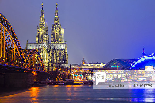 Deutschland  Köln  Blick auf den beleuchteten Kölner Dom mit der Hohenzollernbrücke im Vordergrund