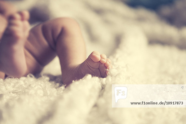 Afroeuropäisches Baby  Füße auf einer kuscheligen weißen Decke