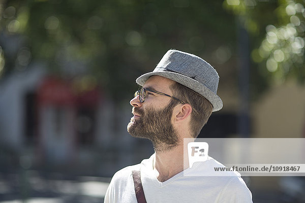 Bearded man outdoors wearing hat and glasses