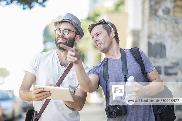 Zwei Männer mit digitalem Tablett im Freien