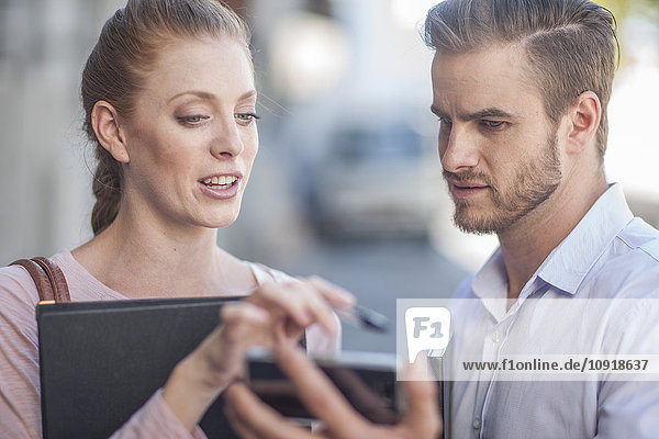 Businessman and woman discussing work  using digital tablet