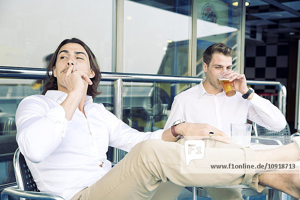 Zwei junge Männer rauchen und trinken Bier auf dem Kreuzfahrtschiff