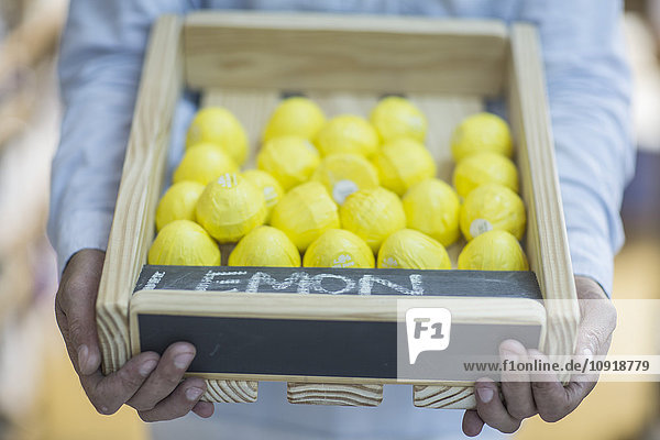 Man holding crate of lemons