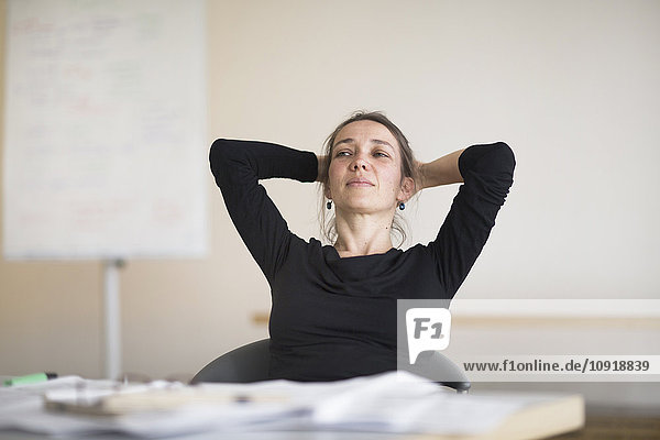 Woman in office leaning back