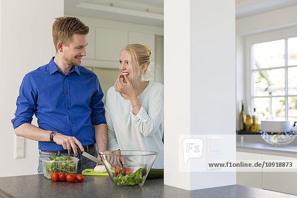 Paar in der Küche beim Zubereiten eines Salats