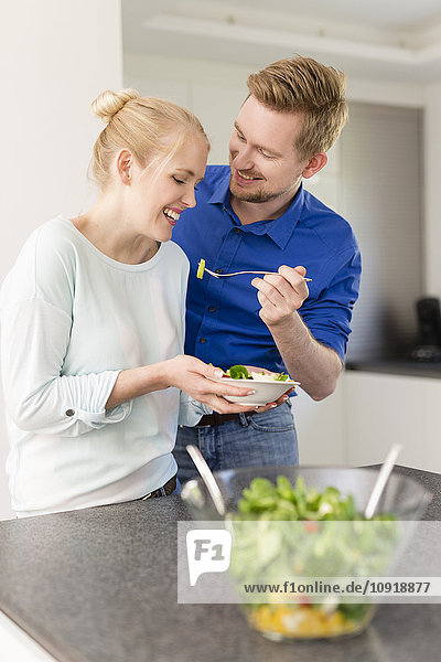 Glückliches Paar in der Küche mit Salat