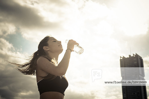 Athletisches Teenagermädchen trinkt Wasser aus der Flasche