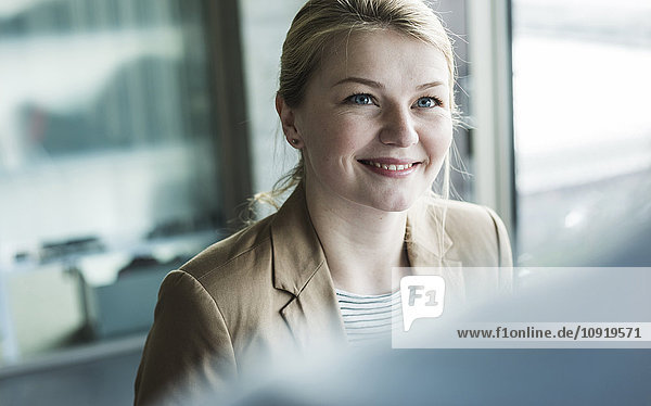 Smiling young woman in office looking at colleague