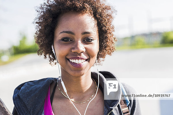 Portrait of smiling young woman listening to music