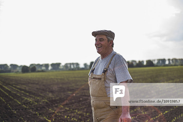 Smiling farmer standing at a field