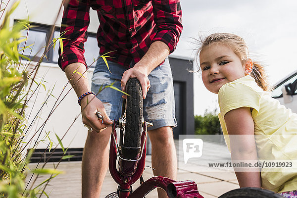 Father and daughter repairing bicycle together