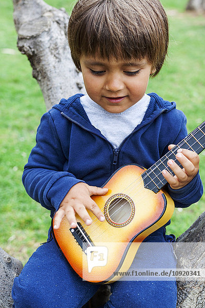 Kleiner Junge spielt Gitarre