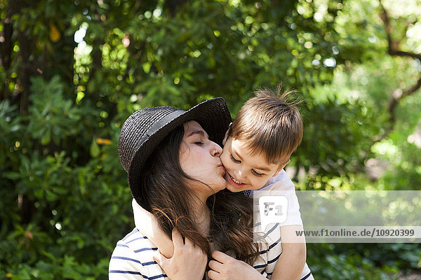 Mother kissing son outdoors