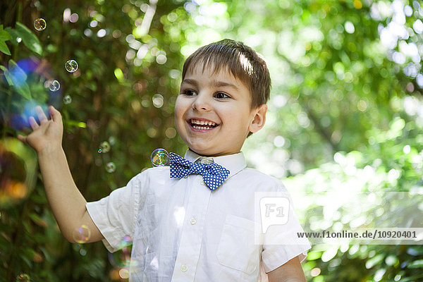 Happy boy playing with soap bubbles