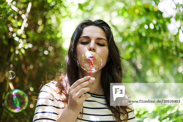 Young woman blowing soap bubbles