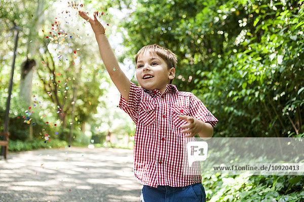 Happy boy playing with confetti