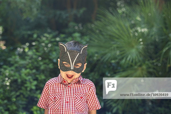 Kleiner Junge mit Tiermaske zieht lustige Gesichter