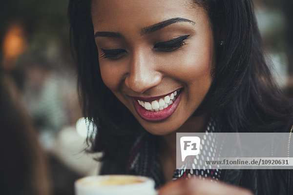 Portrait of happy young woman with cup of coffee