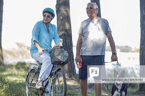 Älteres Paar mit Hund und Fahrrad im Wald